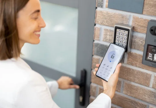 A woman unlocks a high security door with her phone