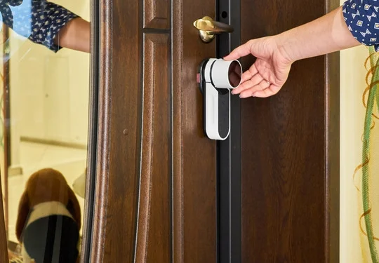 A hand turns a knob on a high security lock