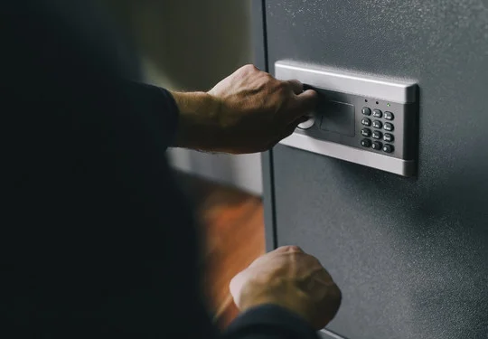 A person opens a safe